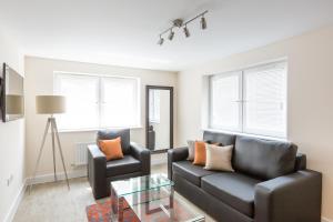 a living room with a couch and a table and two chairs at House of Fisher - Central Gate in Newbury