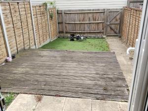 un perro está de pie en una terraza de madera en Diadem Comfort Suites, en Dartford