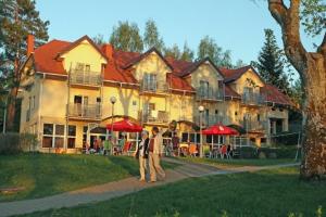 2 personnes debout devant une grande maison dans l'établissement Biały Łabędź, à Kretowiny