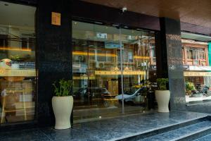 a store front with two white vases on the sidewalk at Jiuding Joy Hotel in Kathmandu