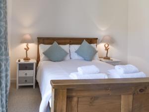 Un dormitorio con una gran cama blanca con dos lámparas. en Coastal Soul - Uk43464, en Sandown