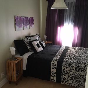 Maison l'héritage في لأنسي سانت جين: غرفة نوم مع سرير مع وسائد سوداء وبيضاء
