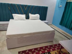 a large bed with two pillows on it in a room at Hotel O Maa Pitambara Palace in Faizābād