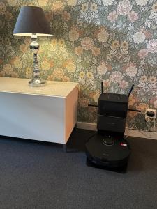 a lamp sitting on a dresser next to a printer at Gamletull Guesthouse in Halmstad