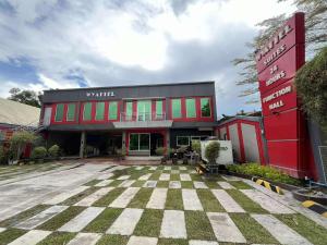 a red building with a checkered courtyard in front at Wyattel Suite in San Manuel