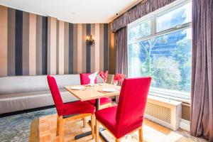 a dining room with a table and red chairs at Dancenter Seaside Retreat Poole in Bournemouth