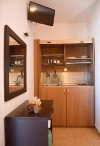 een keuken met houten kasten en een wastafel bij Rodolithos Beach Studios in Stavros