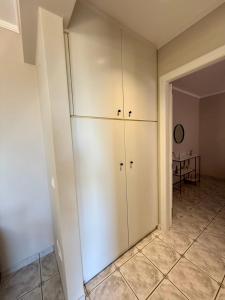 a living room with white cabinets and a table at Casa Limone in Argostoli +11 photos