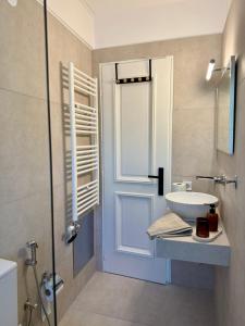 a bathroom with a white sink and a door at Casa Limone in Argostoli