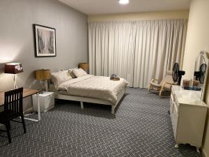 Apartment in Ajman في عجمان: غرفة فندق بها سرير ومكتب