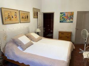 a bedroom with a white bed and pictures on the wall at Chez Christel in Apt