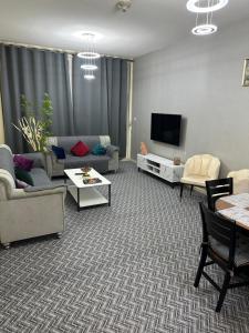 Apartment in Ajman في عجمان: غرفة معيشة مع أريكة وتلفزيون