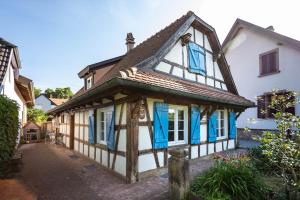 an old house with blue shutters on a street at La maison alsacienne in Strasbourg