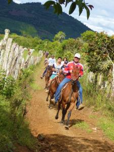 a group of people riding horses down a dirt road at Finca El Cielo in San Agustín