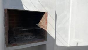 a brick fireplace in a room with a white curtain at Little Anchor - Bachelor Flat in Witsand