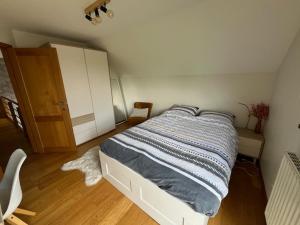 a bedroom with a bed and a wooden floor at chambre d'hôte Francorchamps in Francorchamps