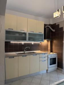 a kitchen with white cabinets and a sink and a stove at Endless summer,Agia Triada in Agia Triada