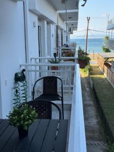 a balcony with two chairs and a bench on a house at Endless summer,Agia Triada in Agia Triada +13 photos