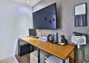 a desk with a computer and a phone on it at Geoje MVG Motel in Geoje