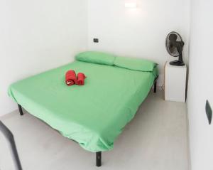 łóżko z dwoma czerwonymi butami na górze w obiekcie La Terrazza sui Quartieri w mieście Neapol