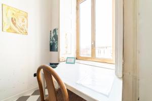 biały pokój ze stołem i oknem w obiekcie La Terrazza sui Quartieri w mieście Neapol