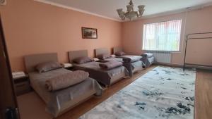 a room with three beds and a couch and a window at Mery in Karakol