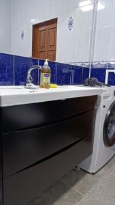 a sink in a bathroom with a washing machine at Mery in Karakol