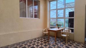 a table and chairs in a room with a window at Mery in Karakol