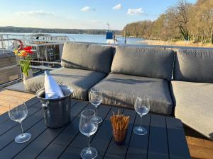 巴特萨罗皮斯库夫TraumZeitBoot Helmut auf dem Scharmützelsee Bad Saarow的一张桌子、酒杯和一张沙发