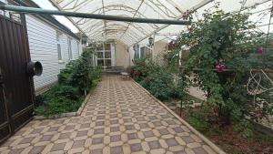 a greenhouse with a brick walkway in a garden at Mery in Karakol