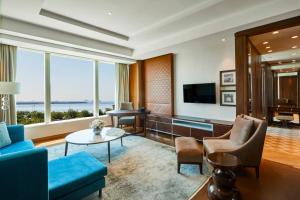 a living room with a blue couch and a tv at Hyatt Regency Istanbul Atakoy in Istanbul