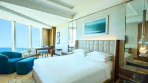 a bedroom with a large white bed and a blue couch at Hyatt Regency Istanbul Atakoy in Istanbul