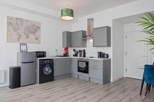 cocina con fogones y lavavajillas en Airy and Modern 1 BR apartment walk to centre, en Belfast