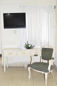 Zimmer mit einem Schreibtisch, einem Stuhl und einem TV in der Unterkunft Hotel Metropolitan I in Irapuato
