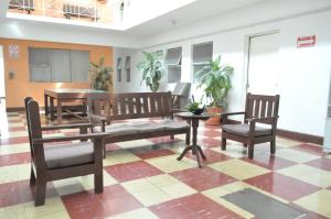 a room with two benches and a table and chairs at Hotel Metropolitan I in Irapuato