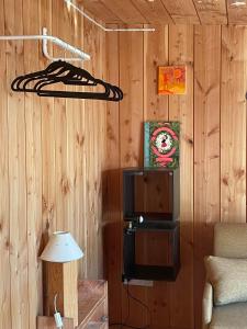 a room with wooden walls with a tv and a lamp at Studio bois avec terrasse et jardin bassin et océan in Le Teich