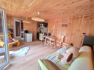 a living room with a couch and a kitchen at Studio bois avec terrasse et jardin bassin et océan in Le Teich +15 photos