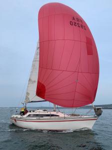 a red and white sail boat on the water at Voilier Rush Régate Capobar in Boulogne-sur-Mer