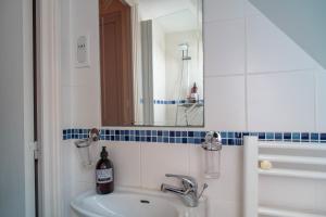 a bathroom with a sink and a mirror at Ker West in Carnac +16 photos