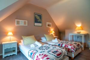 two beds in a attic room with two lamps at Ker West in Carnac
