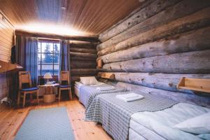 a bedroom with two beds in a log cabin at Santa's Villa Borealis in Luosto