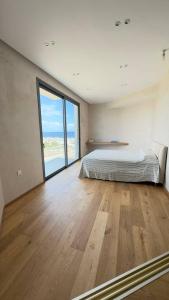 a bedroom with a bed and a large window at One Bedroom Retreat with sea view in Aglantzia