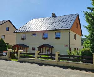a large white house with a metal roof at Apartmán Karovi in Deštné v Orlických horách
