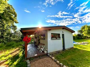 a tiny house with a deck in a field at U Singlu in Nové Město pod Smrkem
