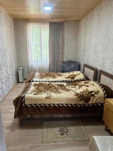 a bedroom with a bed and a window in it at Guest House Vivaushba in Bagvdanari