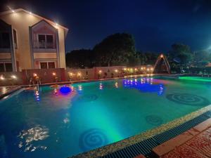 a swimming pool at night with lights on it at The Sea Horse in Mandarmoni