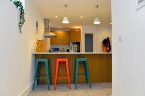 a kitchen with two orange and blue stools at a counter at 10A Ruston Chambers Free parking, Luxury 2 bedroom city center apartment in St Ives +9 photos