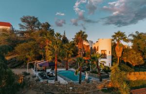 an aerial view of a resort with a pool and palm trees at Heinitzburg Boutique Hotel in Windhoek