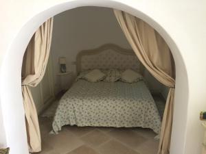 a bedroom with a bed with an archway at TRULLO del CAVALIERE delle GRAVINE in Castellaneta