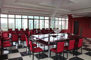 a dining room with a large table and red chairs at Hotel Park Green in Poti